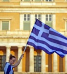 A Greek woman holds a flag in front of the Greek parliament during a protest in Athens, Greece.